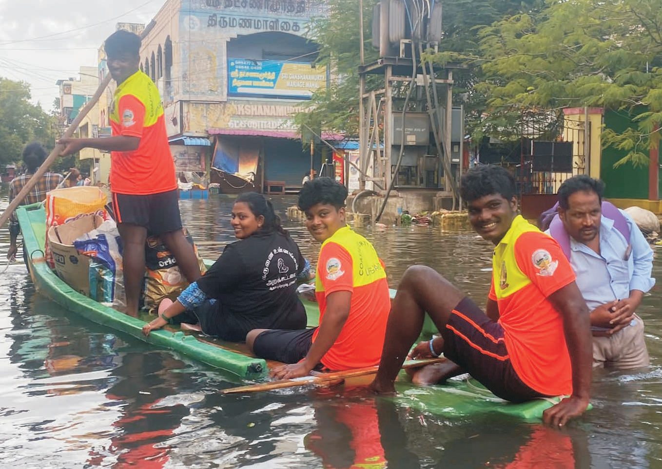 Karunai Ullangal Trust volunteers rowing a rescue boat through flooded Chennai streets